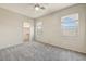 This bedroom has carpet, neutral walls, and two large windows with shades at 13633 W Alvarado Dr, Goodyear, AZ 85395