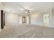 A spacious bedroom with a ceiling fan, carpet, and three access doors at 13633 W Alvarado Dr, Goodyear, AZ 85395