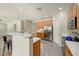 Open concept kitchen with stainless steel appliances, tiled flooring and a breakfast bar at 13633 W Alvarado Dr, Goodyear, AZ 85395