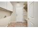 Convenient laundry room with ample cabinet space, built-in shelving, and tile flooring at 13633 W Alvarado Dr, Goodyear, AZ 85395
