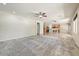 Open floor plan with living room and kitchen, carpeted and tiled floors, and neutral paint at 13633 W Alvarado Dr, Goodyear, AZ 85395
