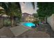 Backyard pool and patio with lush landscaping and mature palm trees at 13633 W Alvarado Dr, Goodyear, AZ 85395