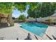 Backyard pool area with desert landscaping, lush green trees, and a fence at 13633 W Alvarado Dr, Goodyear, AZ 85395