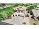 A two-story home featuring a three-car garage, a decorative balcony, and a desert landscape at 1365 N Drexel St, Mesa, AZ 85207