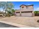 A residence featuring a three-car garage, neutral stucco, stone accents, and low-maintenance desert landscaping at 1365 N Drexel St, Mesa, AZ 85207