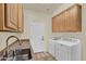 Well-lit laundry room featuring counter space, plenty of storage, and modern washing machines at 1365 N Drexel St, Mesa, AZ 85207