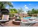 Backyard featuring a pool with waterfall, fire pit, lounging chairs, and decorative lighting at 1365 N Drexel St, Mesa, AZ 85207