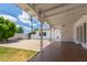 Charming covered patio overlooking a grass backyard, mature trees and white perimeter wall at 1407 E 1St St, Mesa, AZ 85203
