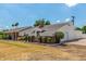 Single-story brick home with a long driveway, a well-manicured lawn, and lush landscaping surrounding the property at 1407 E 1St St, Mesa, AZ 85203