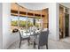 Bright dining area features a glass table, stylish chairs and a beautiful desert view through large windows at 15953 N 111Th Way, Scottsdale, AZ 85255