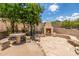 A stone fireplace sits on a stone patio surrounded by desert landscaping with a table and benches nearby at 15953 N 111Th Way, Scottsdale, AZ 85255