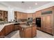 Kitchen features wood cabinetry, granite countertops, an island, and modern appliances at 15953 N 111Th Way, Scottsdale, AZ 85255