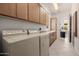 Spacious laundry room with tile floors, wooden cabinets, utility sink, washer, and dryer at 15953 N 111Th Way, Scottsdale, AZ 85255