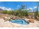 Relaxing backyard spa featuring desert landscaping, stone, and cascading water at 15953 N 111Th Way, Scottsdale, AZ 85255