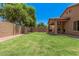 Spacious backyard with lush green grass and a covered patio, ideal for outdoor enjoyment at 16284 W Desert Mirage Dr, Surprise, AZ 85379