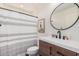 A modern bathroom featuring a stylish vanity with a vessel sink and a shower with a striped curtain at 16284 W Desert Mirage Dr, Surprise, AZ 85379
