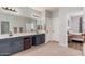 A bright bathroom featuring a double vanity, lots of counterspace, and stylish gray cabinetry at 16284 W Desert Mirage Dr, Surprise, AZ 85379