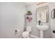 Small powder room with stylish shelving, toilet, and floating sink at 16284 W Desert Mirage Dr, Surprise, AZ 85379