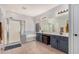 A bright bathroom featuring a shower, tub, double vanity, and stylish geometric tiling at 16284 W Desert Mirage Dr, Surprise, AZ 85379