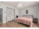 Bright primary bedroom with wood floors, ceiling fan and ensuite bathroom at 16284 W Desert Mirage Dr, Surprise, AZ 85379