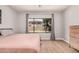 Bright primary bedroom with wood floors and a large window with backyard view at 16284 W Desert Mirage Dr, Surprise, AZ 85379