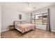 Bright primary bedroom with wood floors and a large window with backyard view at 16284 W Desert Mirage Dr, Surprise, AZ 85379
