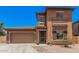 Two-story home with a two car garage, a desert rock yard and a quaint, covered entry way at 16284 W Desert Mirage Dr, Surprise, AZ 85379