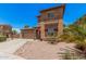 Two-story home with a two car garage, a desert rock yard and a quaint, covered entry way at 16284 W Desert Mirage Dr, Surprise, AZ 85379