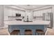 Bright eat-in kitchen featuring a large island with seating, stainless appliances, and white cabinetry at 16284 W Desert Mirage Dr, Surprise, AZ 85379