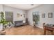 Living room features a comfortable sofa, bright windows, wood floors and neutral paint at 16284 W Desert Mirage Dr, Surprise, AZ 85379