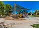 Community playground with colorful equipment under a blue shade structure and sunny blue sky at 16284 W Desert Mirage Dr, Surprise, AZ 85379