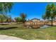 Community pond surrounded by lush greenery with home in the background on a bright day at 16284 W Desert Mirage Dr, Surprise, AZ 85379