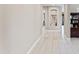 Spacious hallway featuring hardwood floors, an alcove shelf, and a view into other rooms at 16404 S 18Th Dr, Phoenix, AZ 85045