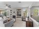 Spacious living room with a fireplace, neutral color palette, ceiling fan and many windows at 16404 S 18Th Dr, Phoenix, AZ 85045