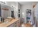 Bright bathroom with dual sinks, custom cabinets, decorative mirrors, tile floors, and a walk-in closet at 16404 S 18Th Dr, Phoenix, AZ 85045