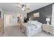 A spacious main bedroom with a ceiling fan, carpeting, a dresser, and access to the en-suite bathroom at 16404 S 18Th Dr, Phoenix, AZ 85045
