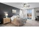 An inviting main bedroom with a decorative accent wall, ceiling fan, and access to the backyard patio at 16404 S 18Th Dr, Phoenix, AZ 85045