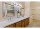 Elegant bathroom featuring double sinks, mirrors, and walk-in closet access at 16716 W Rincon Peak Dr, Surprise, AZ 85387