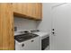 Efficient laundry room with overhead cabinets and new machines, blending functionality with a neat design at 16716 W Rincon Peak Dr, Surprise, AZ 85387