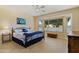Comfortable main bedroom with large window, ceiling fan, and tile flooring at 16716 W Rincon Peak Dr, Surprise, AZ 85387
