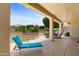 Enjoy outdoor living on this covered patio with a lounge chair and dining set overlooking a landscaped yard at 16716 W Rincon Peak Dr, Surprise, AZ 85387