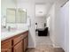 Bright bathroom featuring a modern vanity with a marble countertop and a view into an adjacent bedroom at 17413 W Mandalay Ln, Surprise, AZ 85388