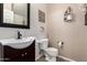 Charming half bathroom with stylish vanity, bronze faucet, and decorative wall shelves at 17413 W Mandalay Ln, Surprise, AZ 85388