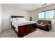 Bedroom featuring a large bed, a comfy sofa, and a bright, sunny window at 17413 W Mandalay Ln, Surprise, AZ 85388