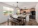 Eat-in kitchen with decorative light fixtures, modern cabinets, stone countertops, and stainless steel appliances at 17413 W Mandalay Ln, Surprise, AZ 85388