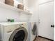Bright laundry room with washer, dryer, and storage shelf above at 17413 W Mandalay Ln, Surprise, AZ 85388