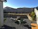 Relaxing backyard boasting a fire pit with chairs, a decorative rock wall, gravel landscaping, and string lights at 18230 W Poston Dr, Surprise, AZ 85387