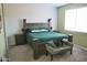 Cozy bedroom featuring a large bed, side tables, and carpet flooring at 18230 W Poston Dr, Surprise, AZ 85387