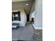 Inviting front porch showcasing a seating area, decorative pillars, and dark front door with sleek hardware at 18230 W Poston Dr, Surprise, AZ 85387