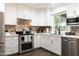 Modern kitchen with white cabinets, stainless steel appliances, and a mosaic backsplash at 1894 E Julie Dr, Tempe, AZ 85283